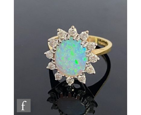 An 18ct hallmarked faux opal and diamond cluster ring, central oval faux opal within a border of twelve individually set diam