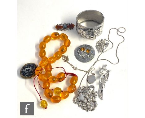 A small parcel lot of assorted jewellery to include five brooches, a white metal buckle bangle, a row of Baltic amber and two
