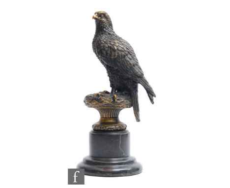 A later 20th Century bronze study, modelled as a stylised falcon perched on a decorative plinth, mounted on a black veined ma