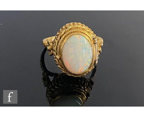 A modern 18ct poison ring with central collar set oval opal to a hinged cover within rope twist borders and flower detail to 