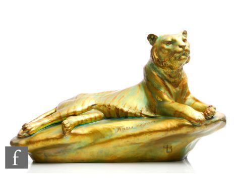 A large Zsolnay eosin glaze model of a tiger reclining on a rock, inscribed Tigus regalis to the front, monogrammed to the fr