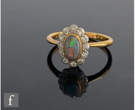 An early 20th Century 18ct opal and diamond cluster ring, central oval cabochon cut opal within a border of twelve diamonds, 