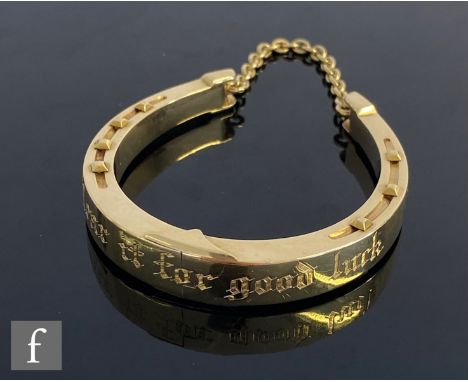 A 15ct novelty hinged, sprung bangle modelled as a studded horseshoe and engraved Wear it for Good Luck, weight 31.5g, unmark