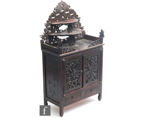 An early 20th Century Anglo Indian hardwood table cabinet fitted with six drawers enclosed by a pair of pierced floral and bi