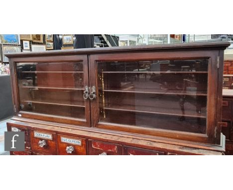 An early 20th Century mahogany wall cabinet, the wooden shelf interior enclosed by a pair of glazed doors, height 43cm x dept