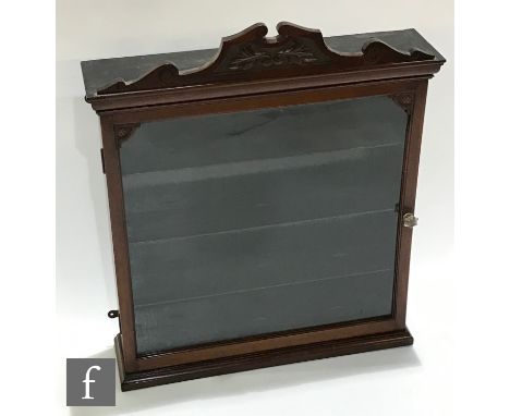 A Victorian mahogany wall cabinet, the fitted shelf interior enclosed by a single glazed door below a scroll carved pediment,