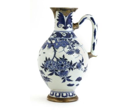 A Chinese blue and white ewer, Kangxi (1662-1722), of baluster form, painted with a bird standing on a blossoming branch, fit