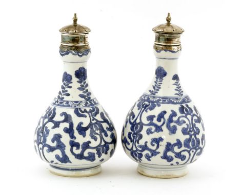 A pair of Chinese blue and white bottles, Kangxi (1662-1722), each of pear shape with a garlic mouth, painted with scrolling 