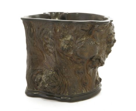 A Chinese wood brush pot, in the natural form of a gnarled tree trunk, with mounted wood rim and wood stand, 22cm high 随形木笔筒