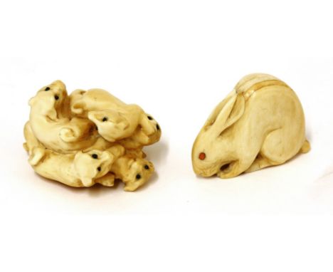 Two Japanese ivory netsuke, early 20th century, one with an hare with coral eyes, 3.7cm, and another, with a group of puppies