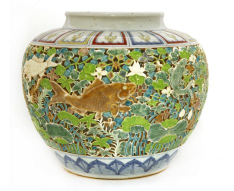 A large Chinese jar, of ovoid tapering form with flared mouth, pierced with carps amongst reeds in a lotus pond, between a fa