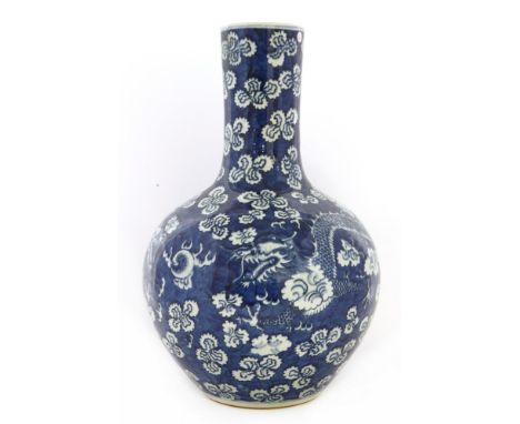 A Chinese blue and white vase, 19th-20th century, painted with two dragons chasing a flaming pearl amongst clouds against a b