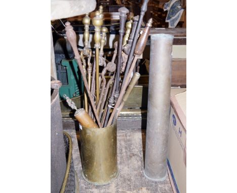 Two artillery shell cases, a selection of fireside tools, three brass fenders and a spark guard