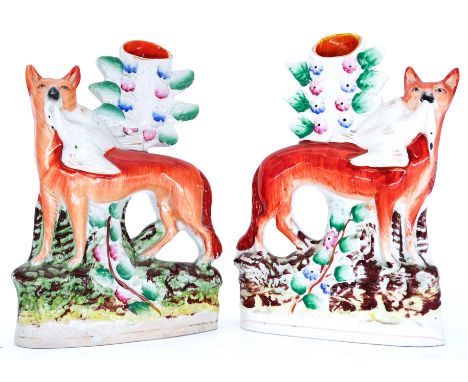 ANIMALS: A pair of Staffordshire Pottery spill vases with figures of Red Foxes, circa 1860,   each modelled standing with a c