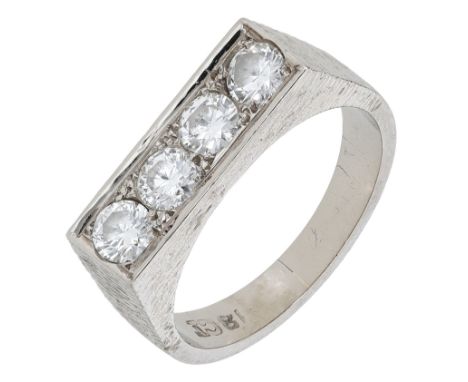 A diamond ring, circa 1970, set with a row of four brilliant-cut diamonds in a textured mount, the band polished, stamped ‘18