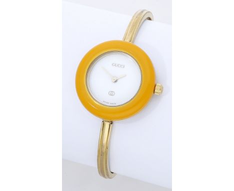 Gucci. A lady’s gold plated wristwatch with interchangeable bezels, Ref. 1100-L, circa 1980. Movement: quartz. Dial: white. C