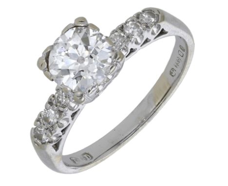 A diamond ring, set with an old brilliant-cut diamond, between similarly-cut diamond shoulders, mounted in 18ct gold, London 