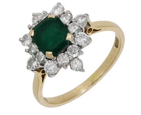 An emerald and diamond ring, the step-cut emerald in a cluster surround of brilliant-cut diamonds, mounted in 18ct gold, Lond