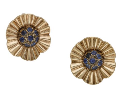 A pair of sapphire ear clips, circa 1940, the stylised flowerheads with a bombé centre of circular-cut sapphires, the undulat