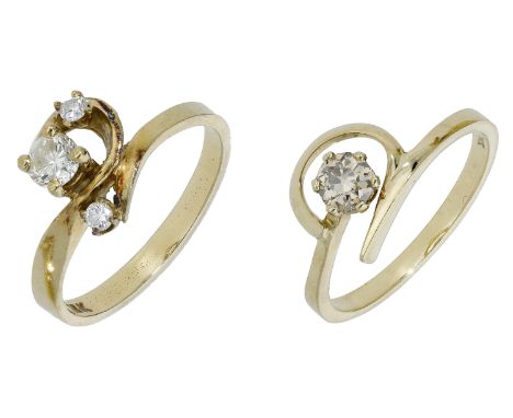 Two diamond dress rings, each of open scrollwork design, the first set with three graduated brilliant-cut diamonds, the secon