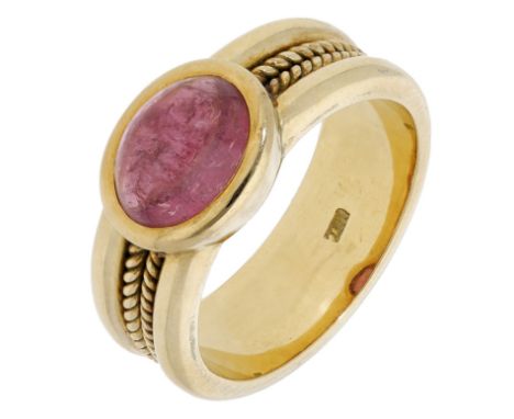 A pink tourmaline ring, the cabochon set to a broad band with ropetwist detailing, stamped ‘750’, ring size M. £300-£500  ---