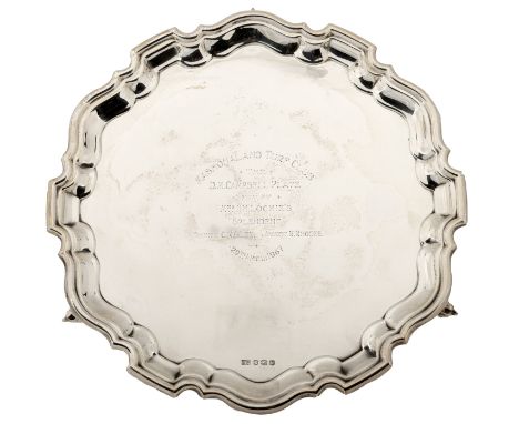 A silver presentation salver, with piecrust border and central inscription, on scroll feet, maker ‘E V’, Sheffield 1962, diam