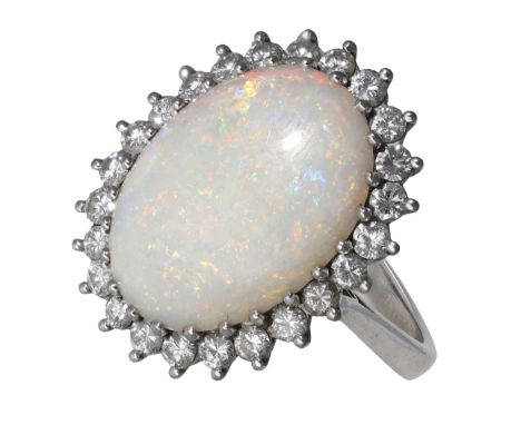 An opal and diamond cluster ring, the oval opal cabochon within a surround of brilliant-cut diamonds, stamped ‘18CT’, total d