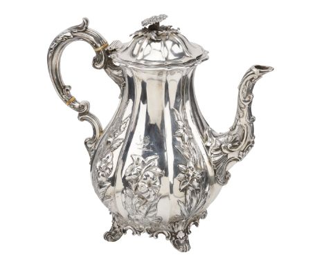 A Victoria silver coffee pot, the pear-shaped body with lobed panels repoussé decorated in high relief with flowering plants,