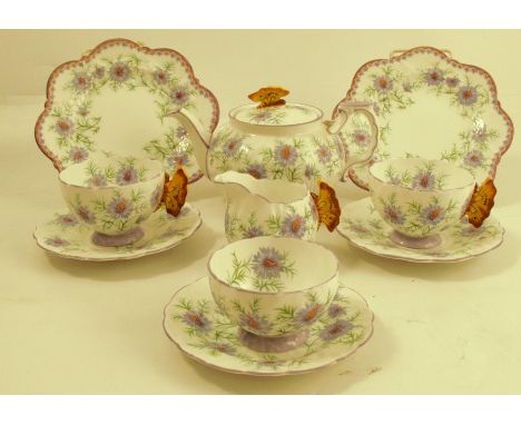 An Aynsley tete-a-tete tea set, decorated with cornflowers and butterfly handles, comprising a tea pot, two cups, two saucers