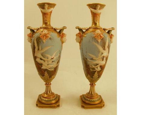 A pair of Royal Worcester vases, one decorated with five swans, the other with four swans, each to a powder blue ground with 
