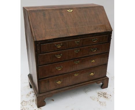 A Georgian walnut bureau, the sloping fall flap opening to reveal pigeonholes and drawers, over four long graduated drawers, 
