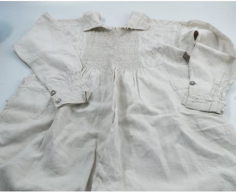 A 19th century North Warwickshire farm workers smock, with button fastener to the neck, smocking panel front and back, stitch
