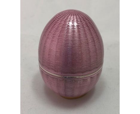 A Russian Faberge silver gilt and pink guilloche enamel egg, in two parts, with plain interior, marked Faberge in Cyrillic wi
