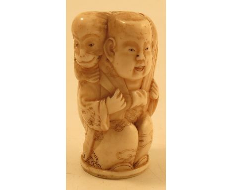 A 19th century Oriental carved ivory walking stick top, carved with a crouched figure with a monkey on his back, height 1.75i