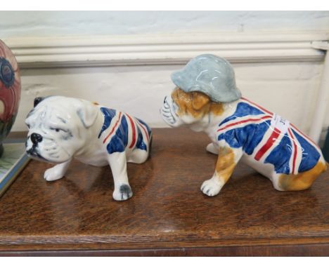 Two Carltonware figures of Bulldogs, both with a Union Jack colours, one wearing a helmet, 15cm high