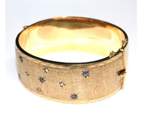 A gem set 9 carat gold bangle