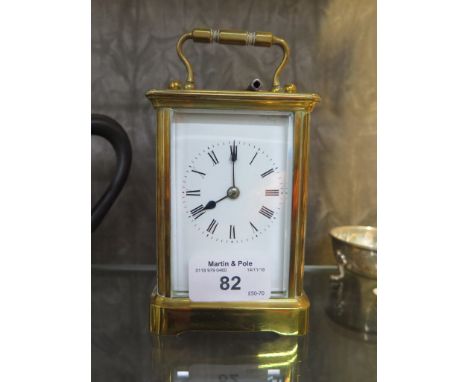 A brass carriage clock, of conventional form with white enamel dial and single train movement 14.5cm high