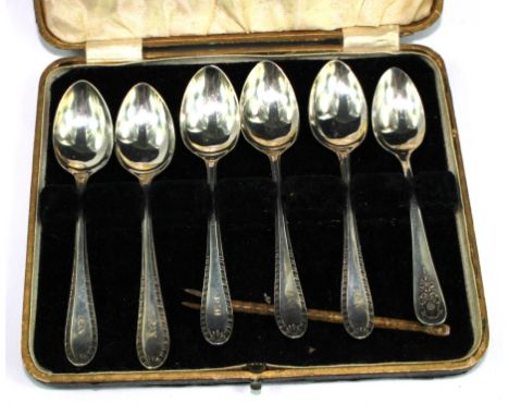 An enamel spoon and five plated teaspoons and six plated coffee spoons
