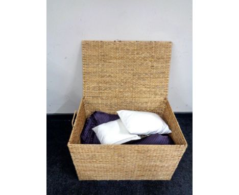 A wicker hamper containing two John Lewis bed throws, curtain tie backs, other soft goods etc.  
