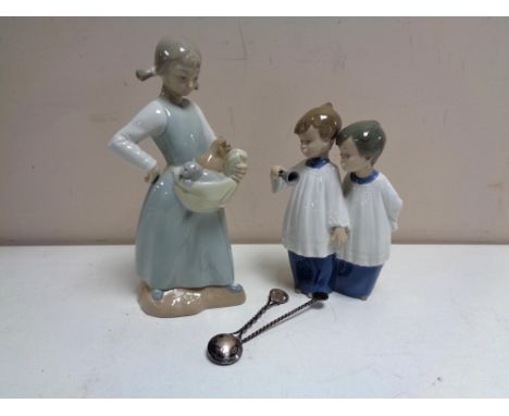 A Nao figure of a girl with kittens, a Nao figure of two choir boys, together with two silver spoons. 