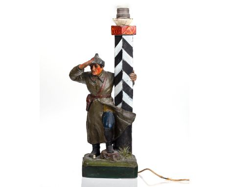 A SOVIET PAINTED GYPSUM LAMP, 1930S the lamp formed as a Red Army soldier on outlook, one hand restring on a signalpost inscr