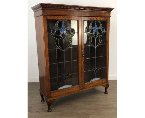 OAK BOOKCASE,with two stained leaded glass doors, 121cm high, 98cm wide, 35cm deepAn oak bookcase top with added legs and pin