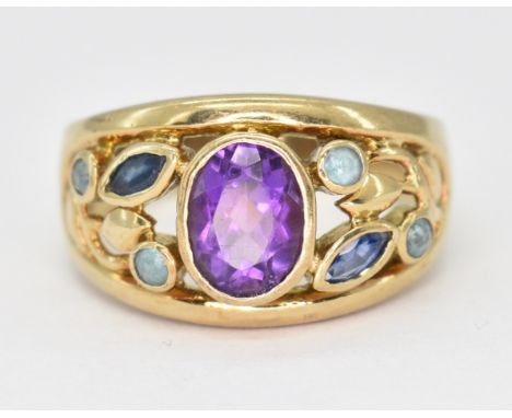 A hallmarked 9ct gold and amethyst ring. The ring having an oval cut amethyst bezel set to the head, with two marquise cut sa