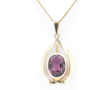 A hallmarked 9ct gold and purple stone pendant necklace. The necklace having a flat link chain with a tear drop shaped pendan