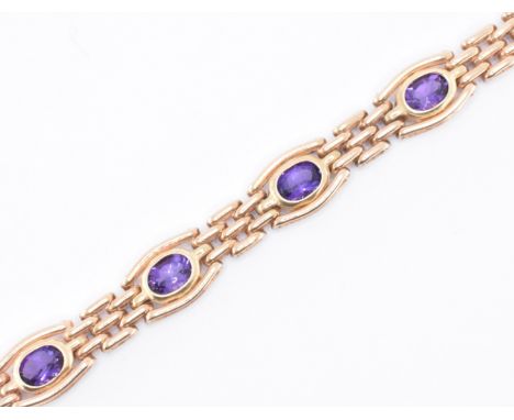 A hallmarked 9ct gold and amethyst gate link bracelet being bezel set with seven oval cut amethysts united by gate links in b