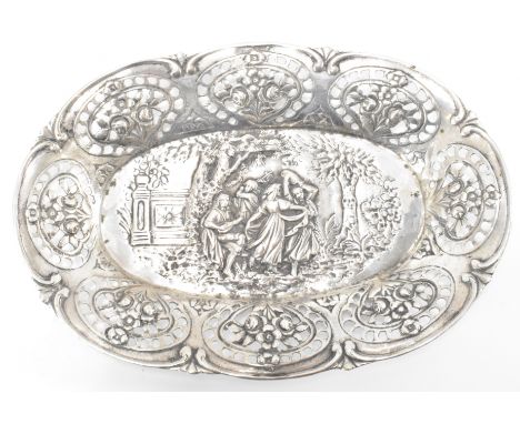 A 20th Century continental silver pin dish / trinket dish of oval form having repousse decoration featuring ladies dancing to