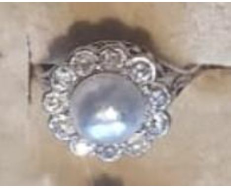 A 9ct gold coral and seed pearl cluster ring. The ring having a round head set with a round coral cabochon surrounded by seed