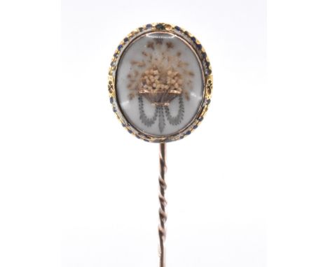 An 18th Century George III gold stick pin. The Georgian antique stick pin having an oval finial featuring a hair work floral 
