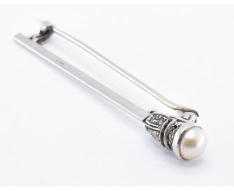 A 1930s Art Deco platinum diamond and pearl brooch pin. The pin having a half pearl to the head with round cut diamonds and o
