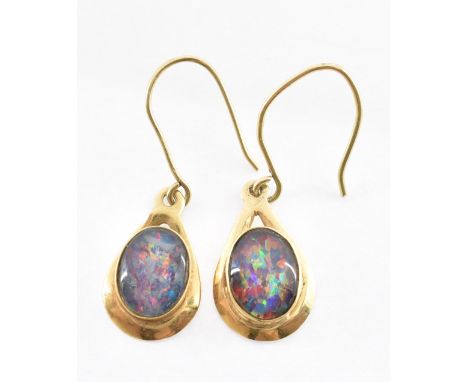 Two 9ct gold simulated opal drop earrings each being set with oval simulated opal panels in 9ct gold settings with hooks to t